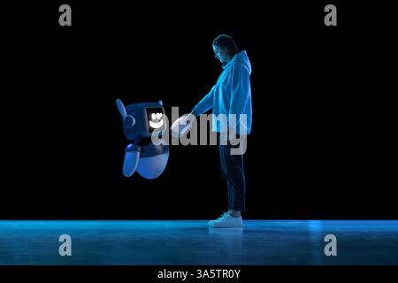 Immagine composita di una giovane donna che interagisce con il modello 3D di robot, stringendo la mano, visualizzando la partnership digitale. Foto Stock