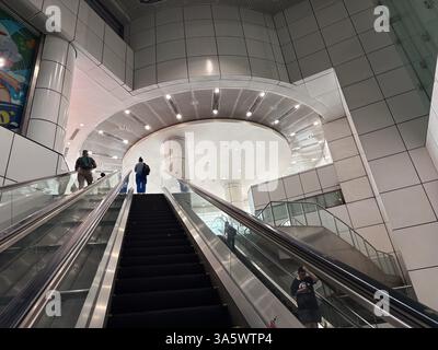Scala mobile nella stazione mrt di Singapore expo. La gente prende le scale mobili all'interno della moderna stazione della metropolitana. Foto Stock