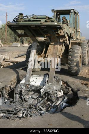 13 novembre 2004; Lutafiyah, Iraq; Lance Cpl. ANTHONY KIOUS della 24th Marine Expeditionary Unit gestisce un veicolo polivalente noto come TRAM. Il TRAM sta collocando un'auto compressa all'interno di un foro di una bomba per veicoli durante la ricostruzione di un ponte a Lutafiyah, Iraq, 13 novembre. Il ponte è stato gravemente danneggiato in ripetuti attacchi da parte di militanti anti anti-iracheni. Il 24° MEU continua a condurre operazioni di sicurezza e stabilità nella provincia settentrionale di Babil. Foto Stock