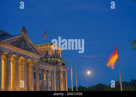 Il Parlamento tedesco catturò durante un crepuscolo estivo sotto una lunga esposizione, con il cielo illuminato alla luce della luna. La bandiera tedesca può essere vista in primo piano - PT 2 Foto Stock