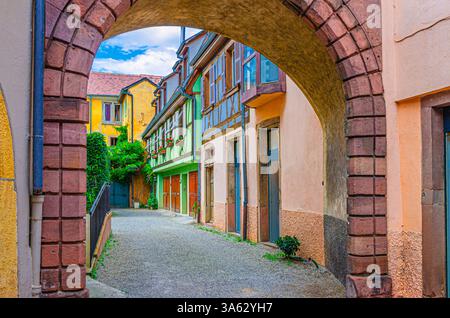 Piccolo e accogliente cortile con vecchie case colorate edifici medievali in stile metà in legno con pareti multicolore e piante verdi nella città vecchia di Colmar Foto Stock