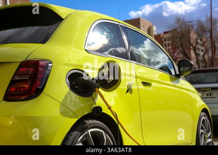 Auto elettrica gialla Fiat Abarth presso un punto di ricarica per il rifornimento di carburante elettrico possiamo anche vedere una ricarica Leapmotor Foto Stock