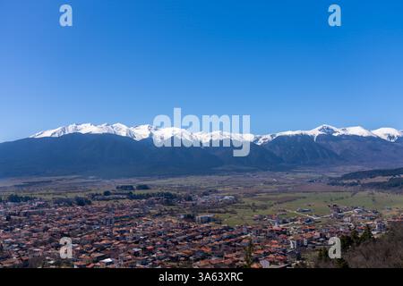 Vista panoramica che cattura la valle del Razlog e la maestosa montagna Pirin, mostrando vette innevate contro un cielo azzurro limpido in Bulgaria Foto Stock