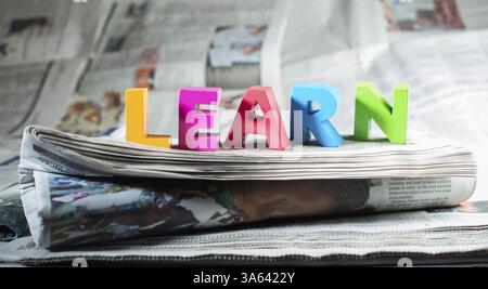 Parola imparare sul giornale. Lettere di legno Foto Stock