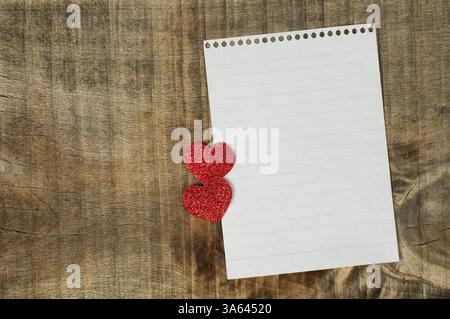 Cuori rossi e il foglio di carta bianco su sfondo di legno Foto Stock