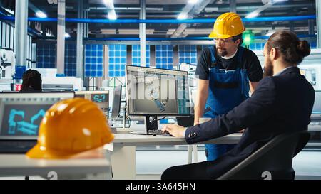 Responsabile dello stabilimento fotovoltaico che mostra agli ingegneri sullo schermo del PC come regolare i parametri del sistema. Specialista che mostra ai collaboratori come ottimizzare l'approvvigionamento energetico nell'impianto di produzione di pannelli solari, telecamera A. Foto Stock