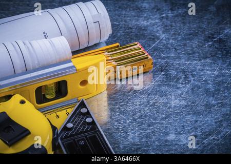 Progetti e strumenti di misurazione a livello di costruzione su un concetto di architettura e di costruzione di superfici metalliche graffiate Foto Stock