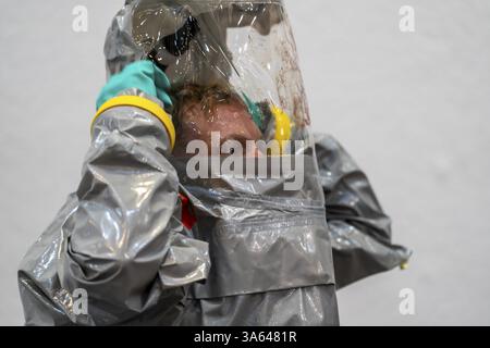 La decontaminazione delle persone ferite dopo un presunto incidente che coinvolge sostanze pericolose, i vigili del fuoco e le organizzazioni umanitarie esercitano la creazione di un Foto Stock