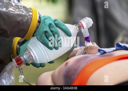 Decontaminazione delle persone ferite dopo un incidente presunto con sostanze pericolose, il paziente viene intubato e ventilato a mano, dai vigili del fuoco e. Foto Stock