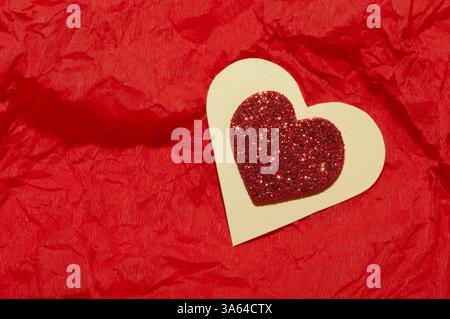 Cuore rosso brocade forma su una carta stropicciata Foto Stock
