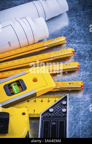 Primo piano dei progetti di costruzione e degli strumenti di misurazione su un concetto di architettura e di costruzione di superfici metalliche graffiate Foto Stock