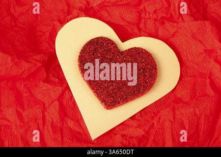 Cuore rosso brocade forma su una carta stropicciata Foto Stock