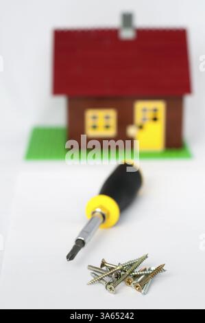 La riparazione e costruzione di casa.il cacciavite e viti di heap Foto Stock