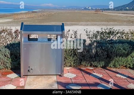 Contenitore per rifiuti in metallo sul passaggio pedonale. Foto Stock