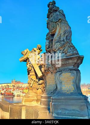 La statua medievale della Madonna e di San Bernardo sul Ponte Carlo contro il fiume Moldava e il Castello di Praga con la Cattedrale di San Vito, Praga, Cechia Foto Stock