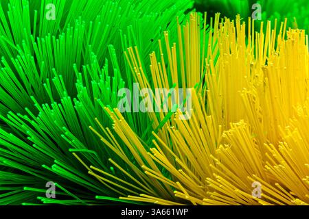 Setole in fibra ottica astratta in verde e giallo vibranti. Primo piano di setole sintetiche colorate Foto Stock