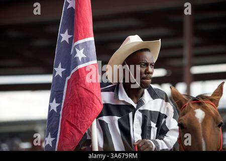 17 ottobre 2004; Angola, LA, USA; un detenuto che fa parte della squadra di equini "Rough Riders" al Penitenziario di stato della Louisiana durante l'Angola Prison Rodeo. I Rough Riders, la squadra di addestramento della prigione, si esibiscono durante le cerimonie di apertura del rodeo. Il rodeo della prigione angola è stato avviato nel 1964 ed è diventato una delle più grandi attrazioni turistiche della Louisiana meridionale. Il rodeo si svolge ogni domenica di ottobre e due fine settimana di aprile. Il penitenziario di stato in Angola si estende su 18.000 acri e confina su tre lati con il fiume Mississippi e conta più di 5.100 detenuti e 1.800 dipendenti. Lo è Foto Stock