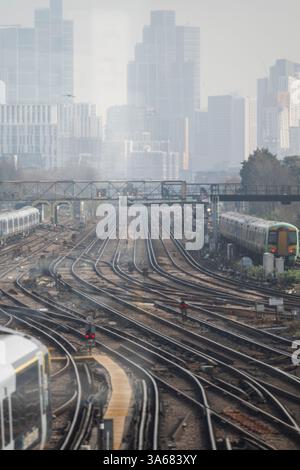 Londra, Regno Unito. 25 marzo 2025. La South Western Railway sarà la prima compagnia operatrice di treni ad essere riportata di proprietà pubblica dal governo laburista nel maggio 2025. South West offre numerosi servizi di pendolari locali e treni a lunga percorrenza dalla stazione di Waterloo a Londra. Immagine: Treni South West (a sinistra) a Clapham Junction. Crediti: Malcolm Park/Alamy Live News Foto Stock