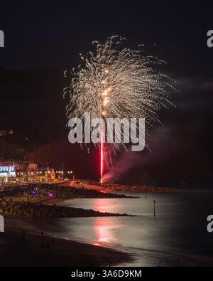 Fuochi d'artificio sul lungomare durante la regata di Sidmouth nell'agosto 2023. Sidmouth Town Beach, Sidmouth, Devon, Inghilterra, Regno Unito. Foto Stock