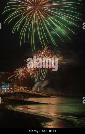 Fuochi d'artificio sul lungomare durante la regata di Sidmouth nell'agosto 2023. Sidmouth Town Beach, Sidmouth, Devon, Inghilterra, Regno Unito. Foto Stock
