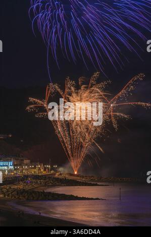 Fuochi d'artificio sul lungomare durante la regata di Sidmouth nell'agosto 2023. Sidmouth Town Beach, Sidmouth, Devon, Inghilterra, Regno Unito. Foto Stock