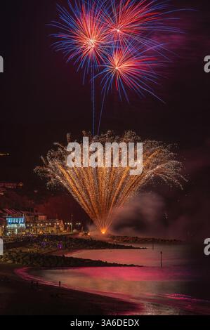 Fuochi d'artificio sul lungomare durante la regata di Sidmouth nell'agosto 2023. Sidmouth Town Beach, Sidmouth, Devon, Inghilterra, Regno Unito. Foto Stock