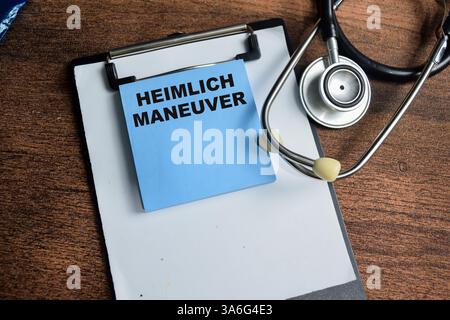 Concetto di manovra di Heimlich scrivere su note adesive isolate su un tavolo di legno. Foto Stock