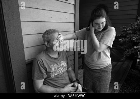 10 giugno 2023, Asheville, Carolina del Nord, Stati Uniti: JOSIE KLAAREN, 22, condivide un momento tenero con suo padre JOSHUA fuori dalla loro casa di Asheville, NC. Joshua è ansioso per il futuro della sua figlia disabile dal punto di vista dello sviluppo in quanto è incontinente e incapace di esprimersi a causa di aprassia. "Chi si prenderà cura di Josie quando io e sua madre non ci saremo più? Possiamo capire il suo discorso limitato e sappiamo i suoi bisogni, ma non siamo riusciti a trovare o assumere assistenti a casa. Nessuno vuole lavorare per i bassi salari che lo Stato sta pagando”, ha detto. (Credit Image: © Robin Rayne/ZUMA Press Wire) UTILIZZO EDITORIALE SU Foto Stock
