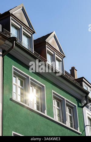 il sole si riflette nella finestra di un vecchio edificio rinnovato Foto Stock