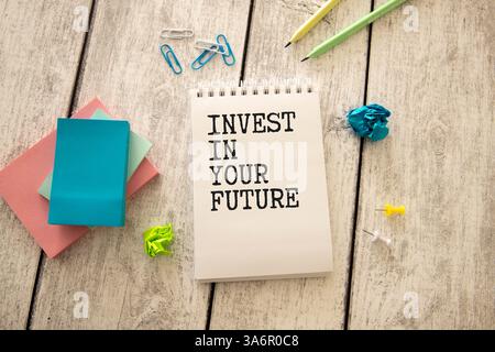 Concetto di business. INVESTIMENTI DI testo PER la scrittura di principianti su notebook con carta strappata, matita e calcolatrice su sfondo in legno. Foto Stock