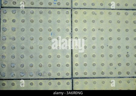 Floor Station Indonesiano. Modello. Primo piano di linee gialle e blocchi gialli testurizzati nelle stazioni ferroviarie come blocchi guida o marciapiedi ciechi Foto Stock