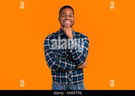 La folgore millenaria africana positiva che si presenta sorridente alla fotocamera, Studio Shot Foto Stock