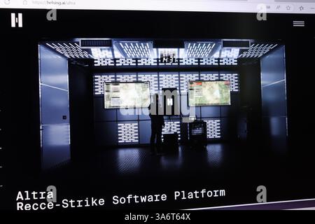 Uomo in sala di controllo high-tech che analizza software militare su più schermi. Foto Stock