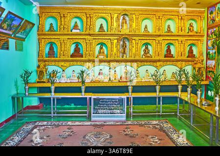 YANGON, MYANMAR - 27 FEBBRAIO 2018: L'altare con le immagini di Buddha donate nel Tempio di Chaukhtatgyi, il 27 febbraio a Yangon. Foto Stock
