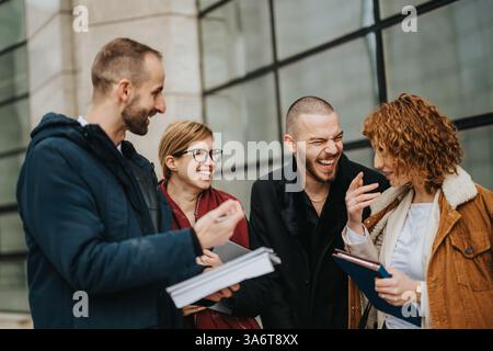 Gruppo di professionisti che collaborano e ridono all'aperto Foto Stock