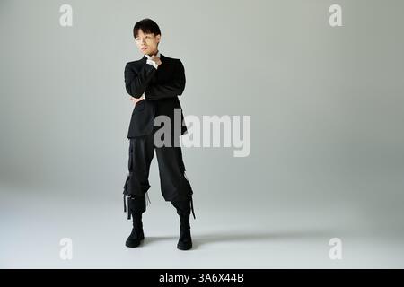 Il bell'uomo asiatico indossa un abbigliamento alla moda, sfoggiando eleganza e stile. Foto Stock
