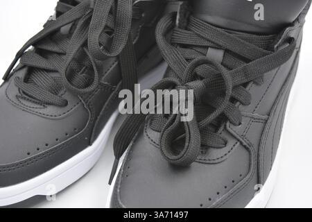 Belle scarpe sportive per giovani, stivali neri con suola rigida bianca su un plast bianco. Semistivali caldi in similpelle con isolamento. Foto Stock