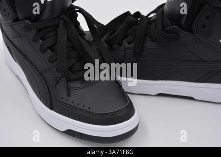 Belle scarpe sportive per giovani, stivali neri con suola rigida bianca su un plast bianco. Semistivali caldi in similpelle con isolamento. Foto Stock