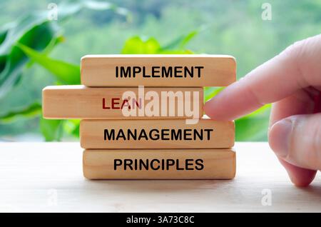 Implementare il testo dei principi di gestione snella su blocchi di legno che rappresentano una strategia di miglioramento continuo. Foto Stock