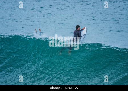 Surfisti nella famosa spiaggia di Supertubos, Peniche, Portogallo Foto Stock