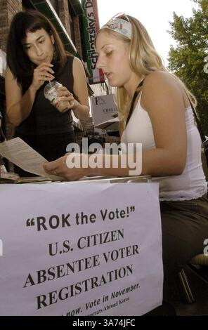 29 agosto 2004; Seoul, COREA DEL SUD; CHRISTINA DELGADO, 24 di Minneapolis Minnesota, (L) aiuta CYNTHIA RAPACZ, 28 di Minneapolis, Minnesota, a compilare il modulo di voto assente per le prossime elezioni presidenziali degli Stati Uniti a Seoul Corea domenica 29 agosto 2004. Circa i 100.000 cittadini statunitensi vivono in Corea del Sud, inclusi i militari statunitensi. Foto Stock