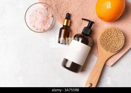 Concetto di trattamento spa, piano con prodotti cosmetici naturali, spazzola per massaggi, asciugamano e frutta d'arancia, vista dall'alto, spazio fotocopie. Anti-cellulite e disintossicazione Foto Stock