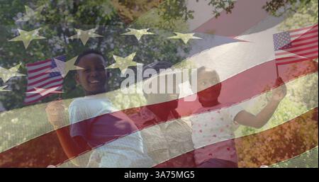 Immagine di un soldato maschio che abbraccia la figlia e il figlio sorridenti sulla bandiera americana Foto Stock