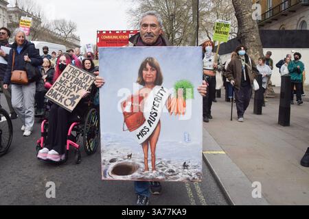 Londra, Regno Unito. 26 marzo 2025. L'artista politico Kaya Mar tiene il suo ultimo dipinto che raffigura Rachel Reeves come "Miss austerity" fuori Downing Street durante una dimostrazione contro i tagli ai benefici. Folle di manifestanti si riunirono a Westminster come Cancelliere dello Scacchiere Rachel Reeves presentò la sua dichiarazione di primavera. Credito: SOPA Images Limited/Alamy Live News Foto Stock