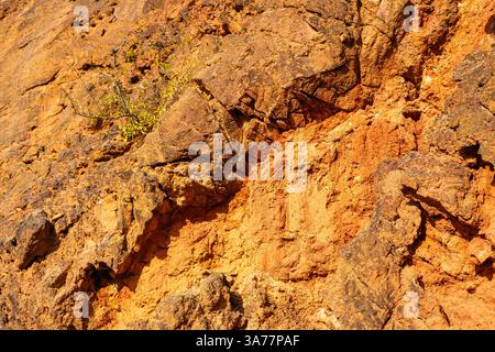 Formazione rocciosa di bauxite erosa con colori arancio brillanti in una miniera di bauxite abbandonata Foto Stock