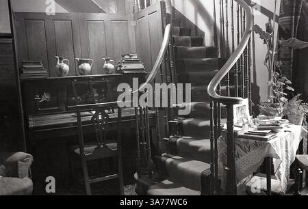 1930, storica scala in legno ornata, con corridore, in una casa di campagna a casa della signora Bowes-Lyon, un membro della nobiltà britannica. Foto Stock