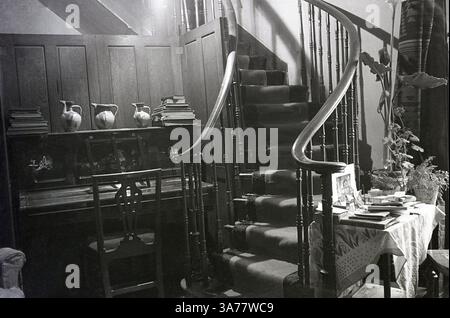 1930, storica scala in legno ornata, con corridore, in una casa di campagna a casa della signora Bowes-Lyon, un membro della nobiltà britannica. Foto Stock