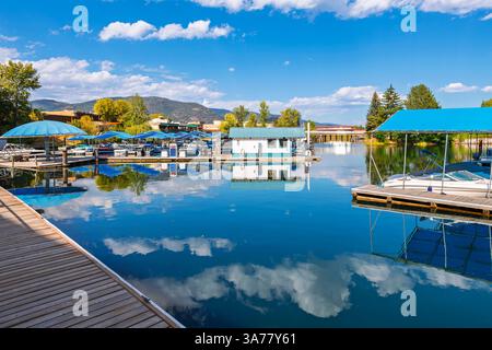 Le barche in scivoli attraccano al porticciolo di Sandpoint, con la strada principale della piccola città di Sandpoint Idaho alle spalle, sul lago Pend Oreille nell'Idaho settentrionale Foto Stock