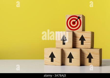Targeting. Piramide di cubi con frecce che puntano verso uno con un mirino sulla parte superiore su sfondo giallo Foto Stock