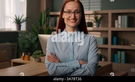 Ritratto ragazza sorridente donna d'affari donna datore di lavoro imprenditrice manager che guarda la fotocamera mani incrociate posa donna d'affari sicura di sé felice Foto Stock